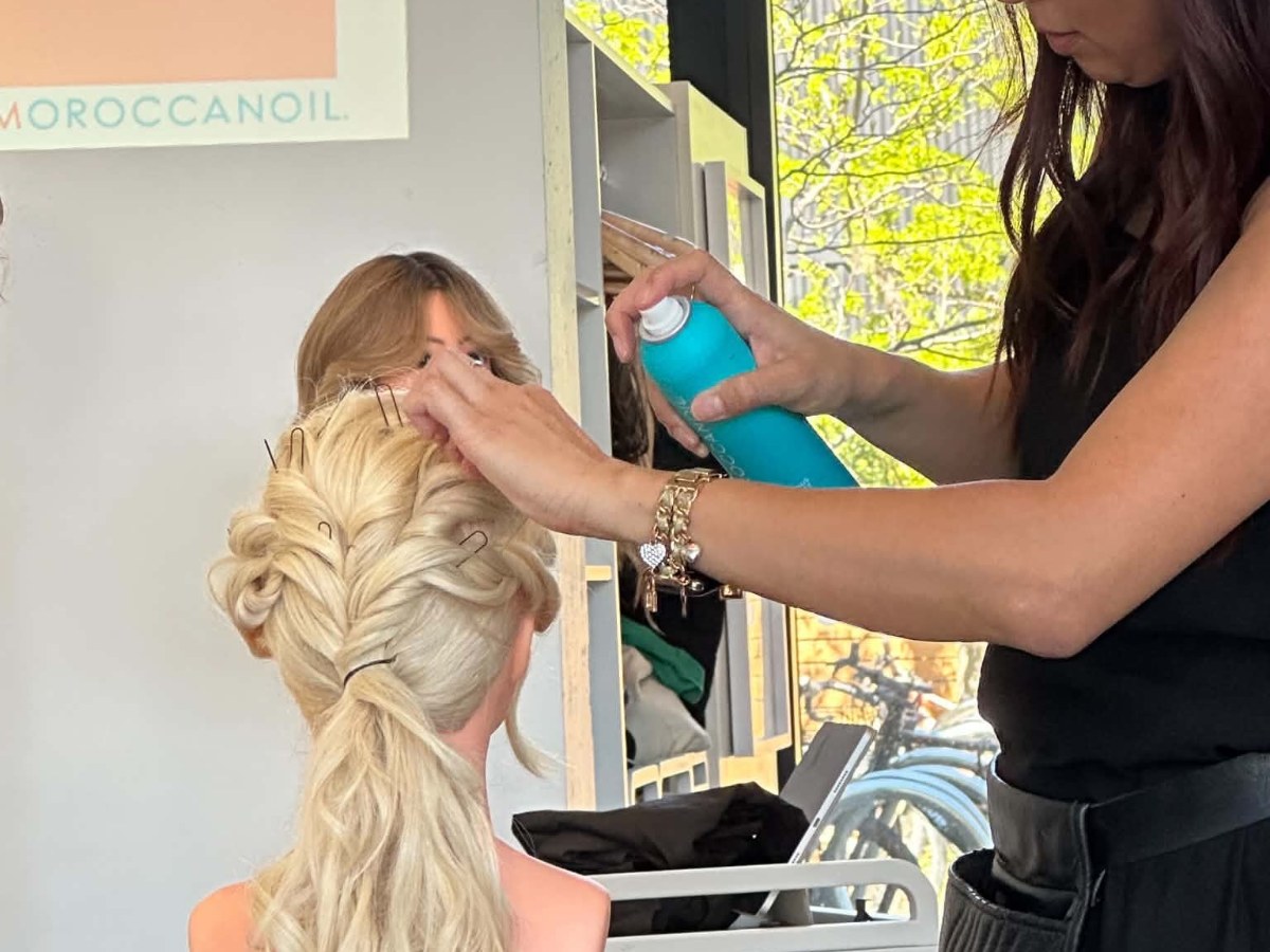 A True Grit stylist finishing a braided style
